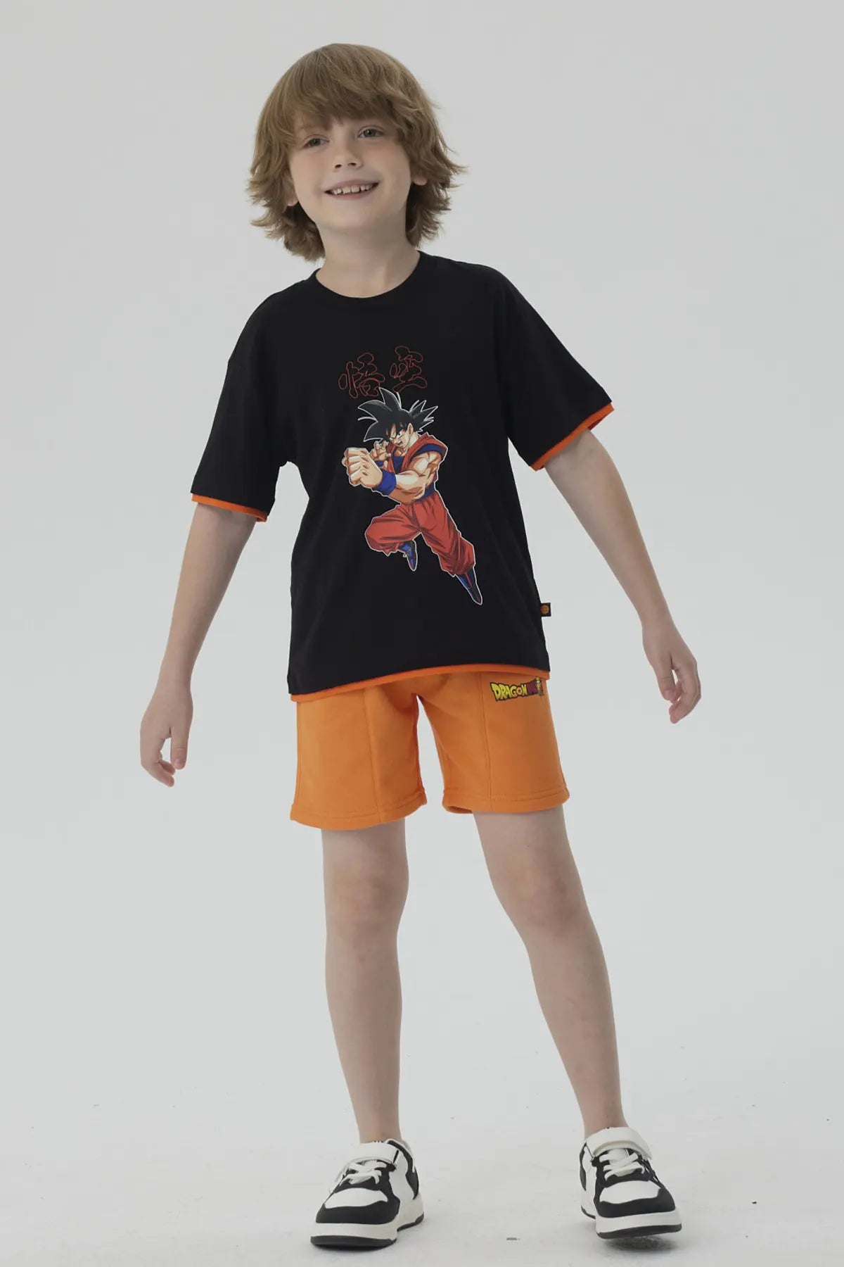 Bermuda Dragon Ball Naranja de algodón y poliéster con estampado de Goku en acción y logo de la serie, ideal para los fanáticos del anime.
