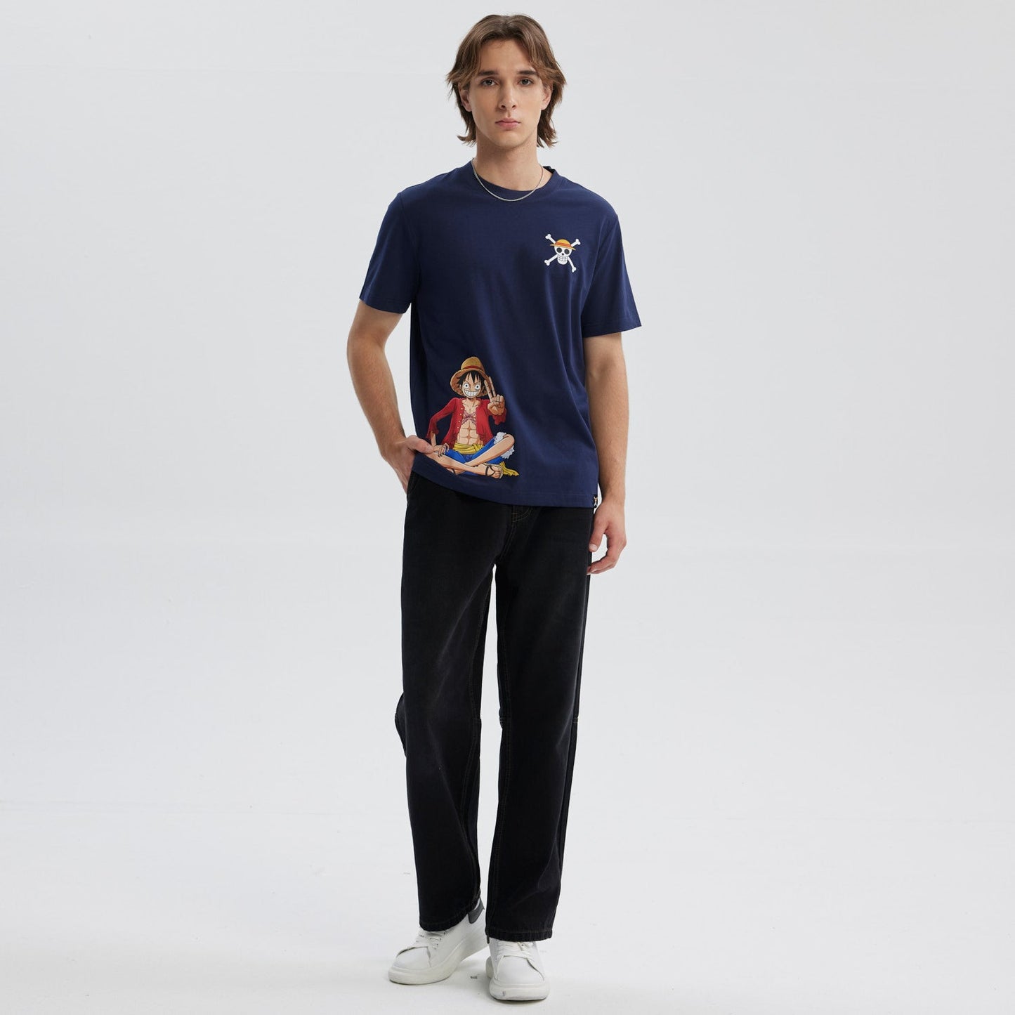 Polera azul marino de algodón con ilustración de Luffy en pose relajada y logo de la calavera pirata en el pecho, inspirado en One Piece.