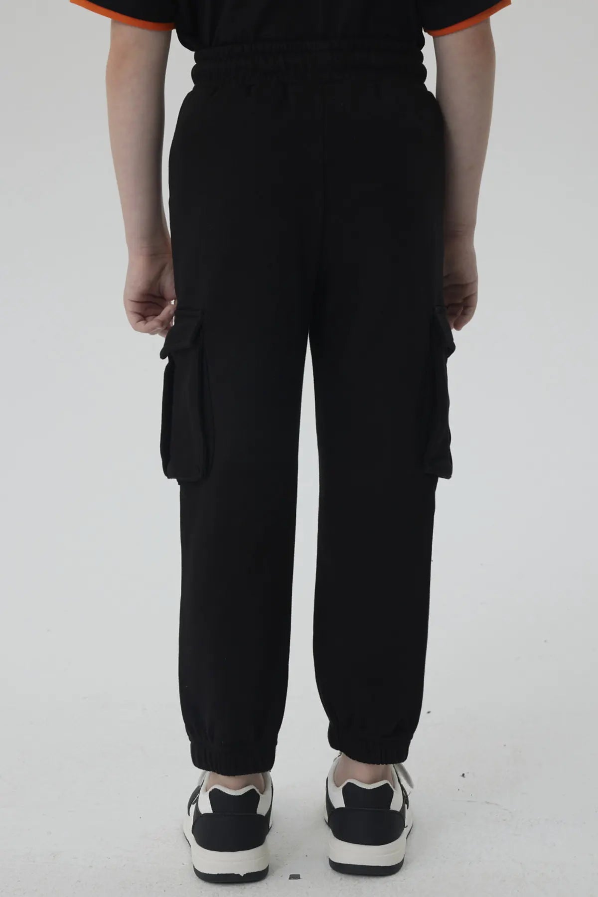 Pantalón buzo negro con detalles en naranja, presenta el icónico logo de Dragon Ball en la pierna, ideal para fans de la saga.