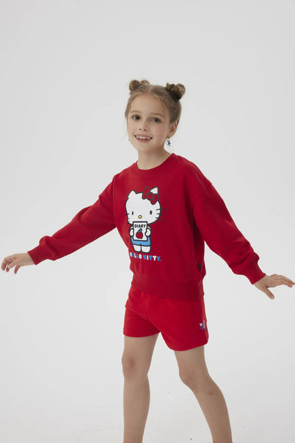 Polerón rojo con ilustración de Hello Kitty sosteniendo un diario, con detalles en azul y el texto 'HELLO KITTY' en la parte inferior, ideal para fans de la icónica gatita.
