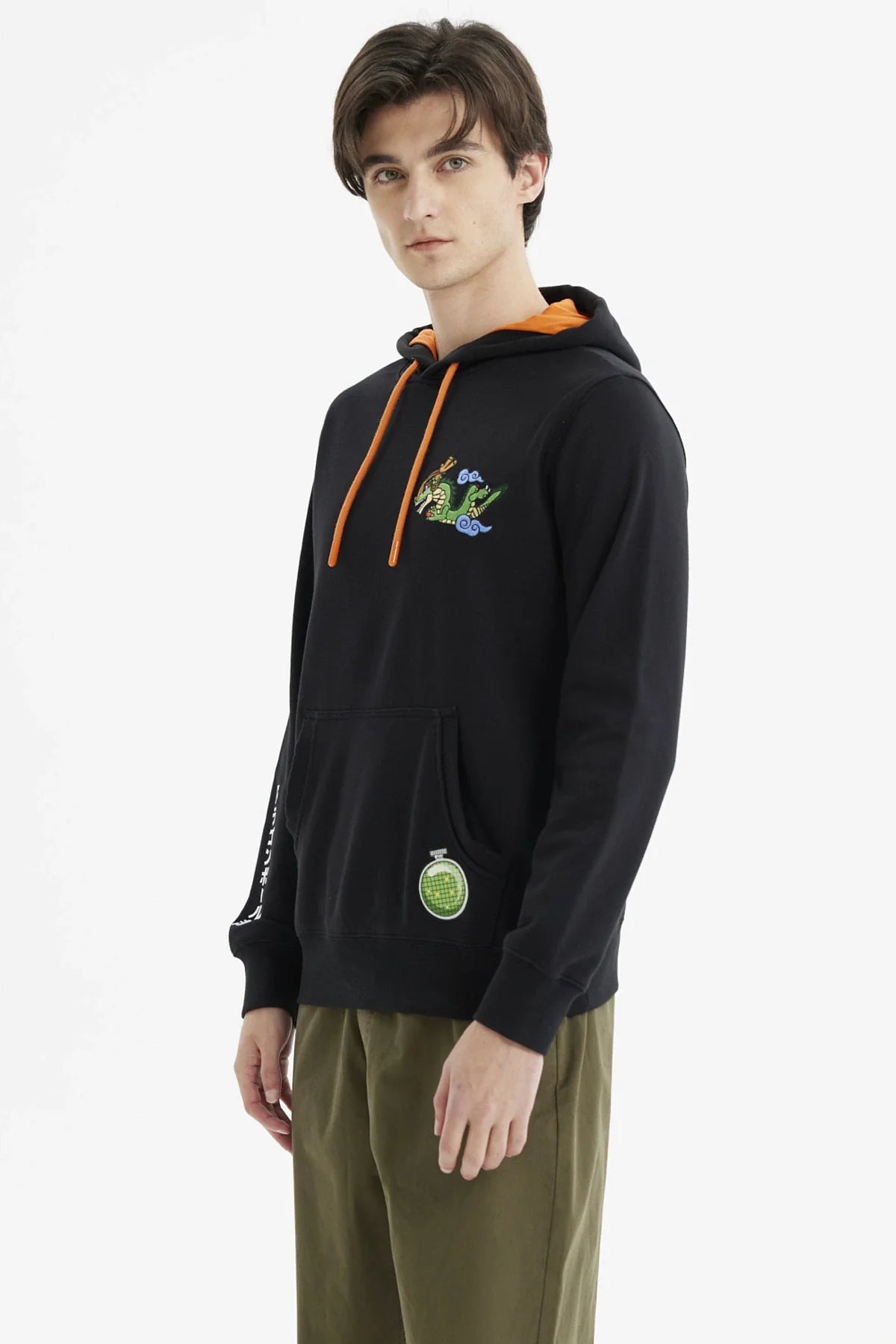 Polerón negro con capucha y detalles en naranja, presenta a Shenlong en estilo ilustración, con un dragón verde y nubes, y la esfera del dragón en la parte inferior.