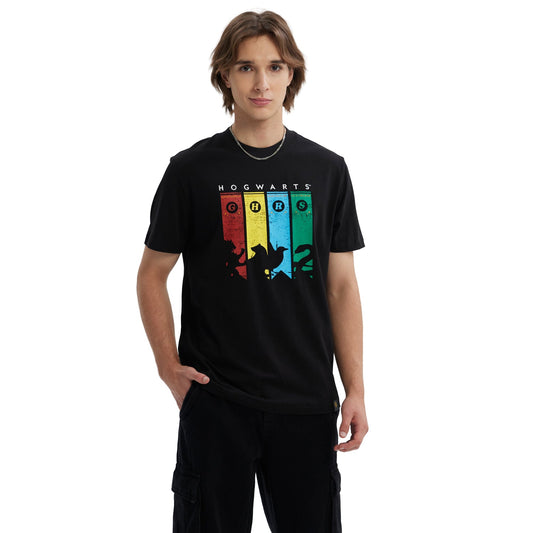 Polera negra de Harry Potter con estampado colorido que muestra siluetas de criaturas mágicas y el texto 'HOGWARTS' en la parte superior, evocando la magia del universo de J.K. Rowling.