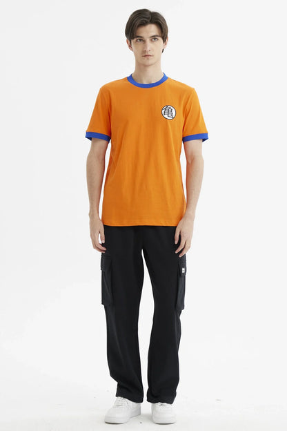 Polera naranja de Dragon Ball con ribete azul, presenta el icónico símbolo de Kame en el pecho, perfecta para fans de la saga.