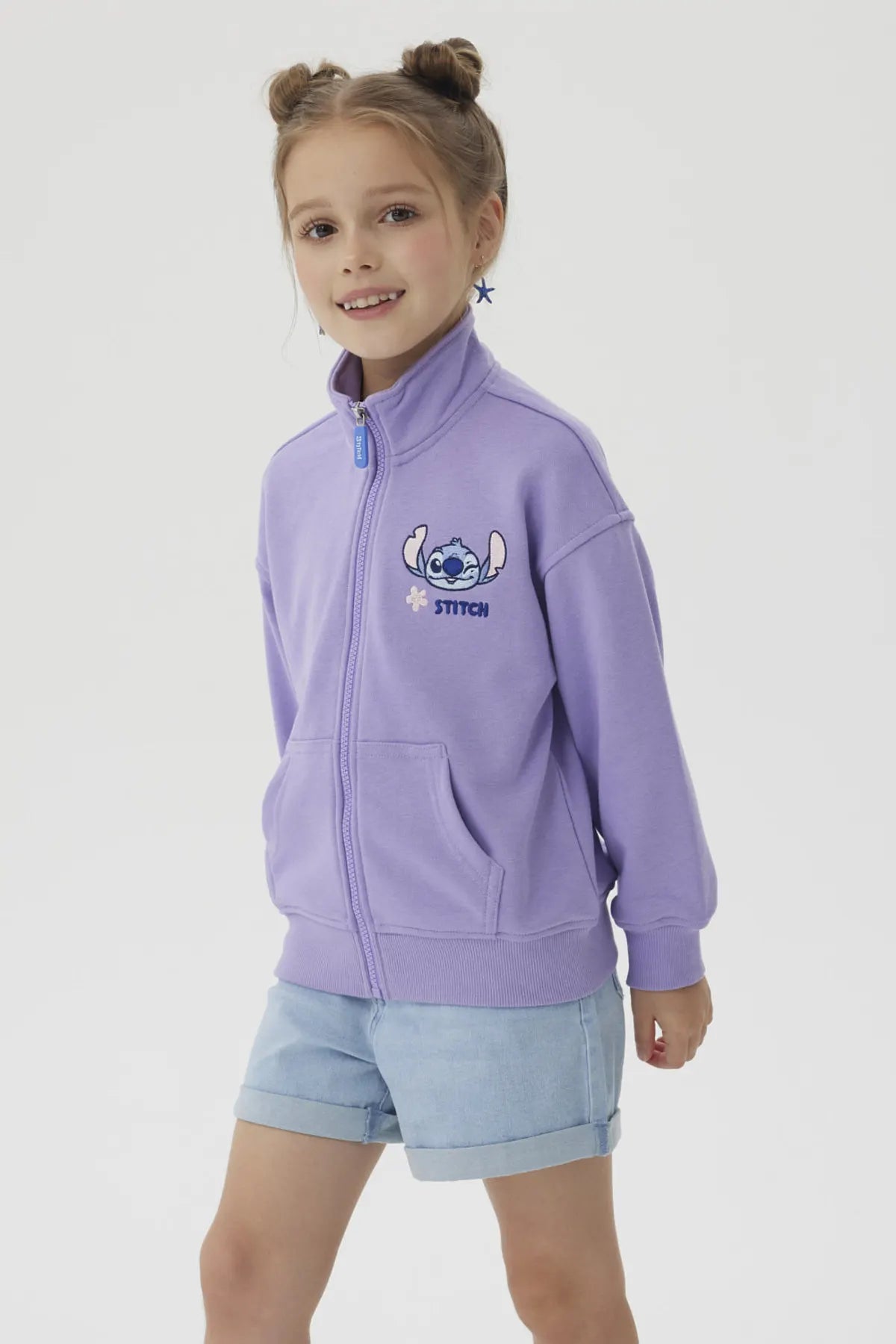 Polerón lila con diseño de Stitch, presenta un bordado colorido del personaje en el pecho y un cierre frontal, ideal para fans de Disney.