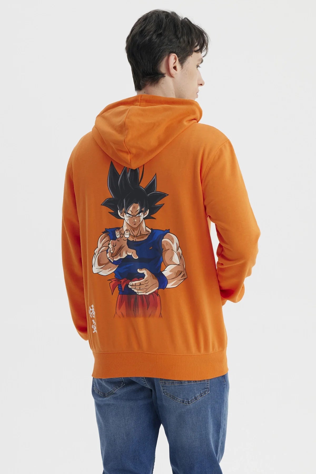 Polerón naranjo con capucha de Dragon Ball, presenta el icónico símbolo de Goku en el pecho, ideal para fanáticos de la saga.