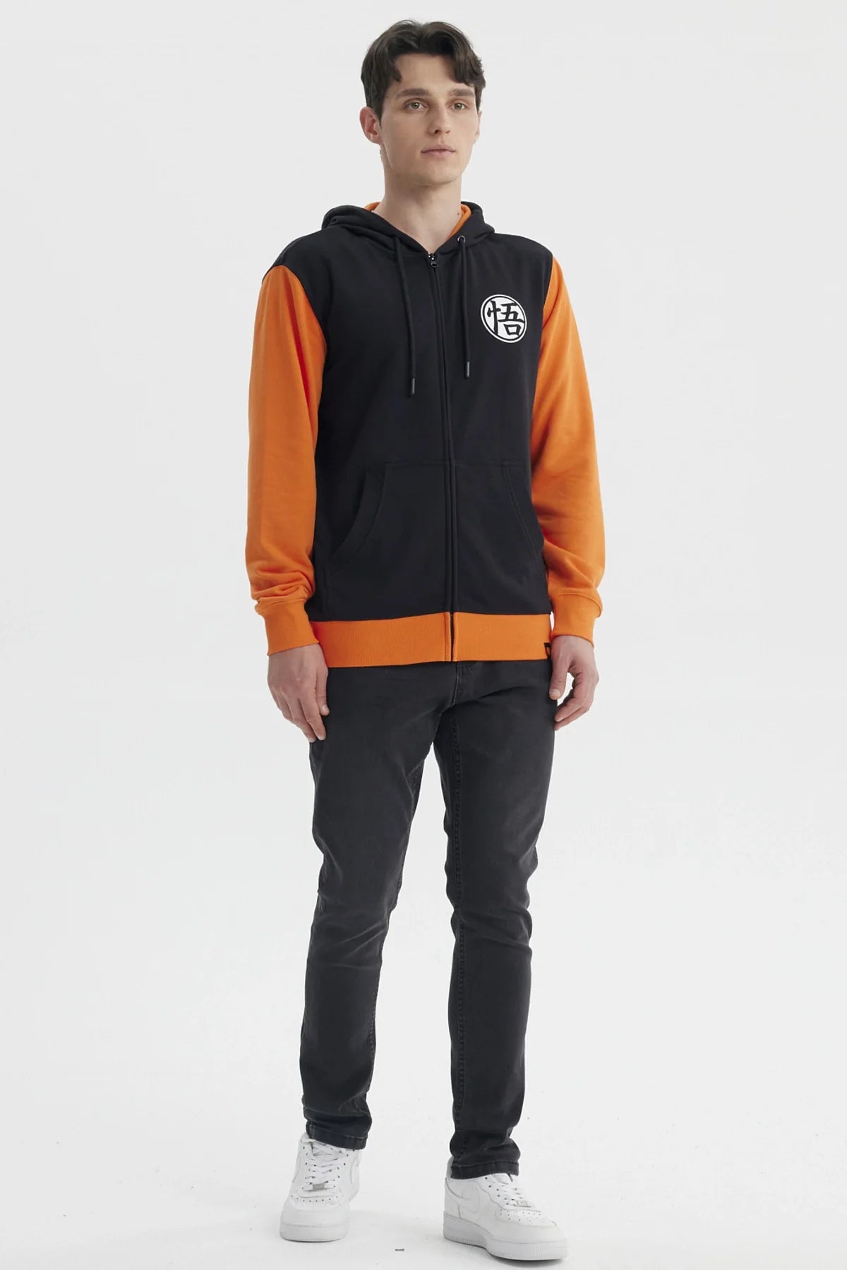 Polerón negro con mangas naranjas, presenta el símbolo de Goku en el pecho, ideal para fans de Dragon Ball que buscan estilo y comodidad.