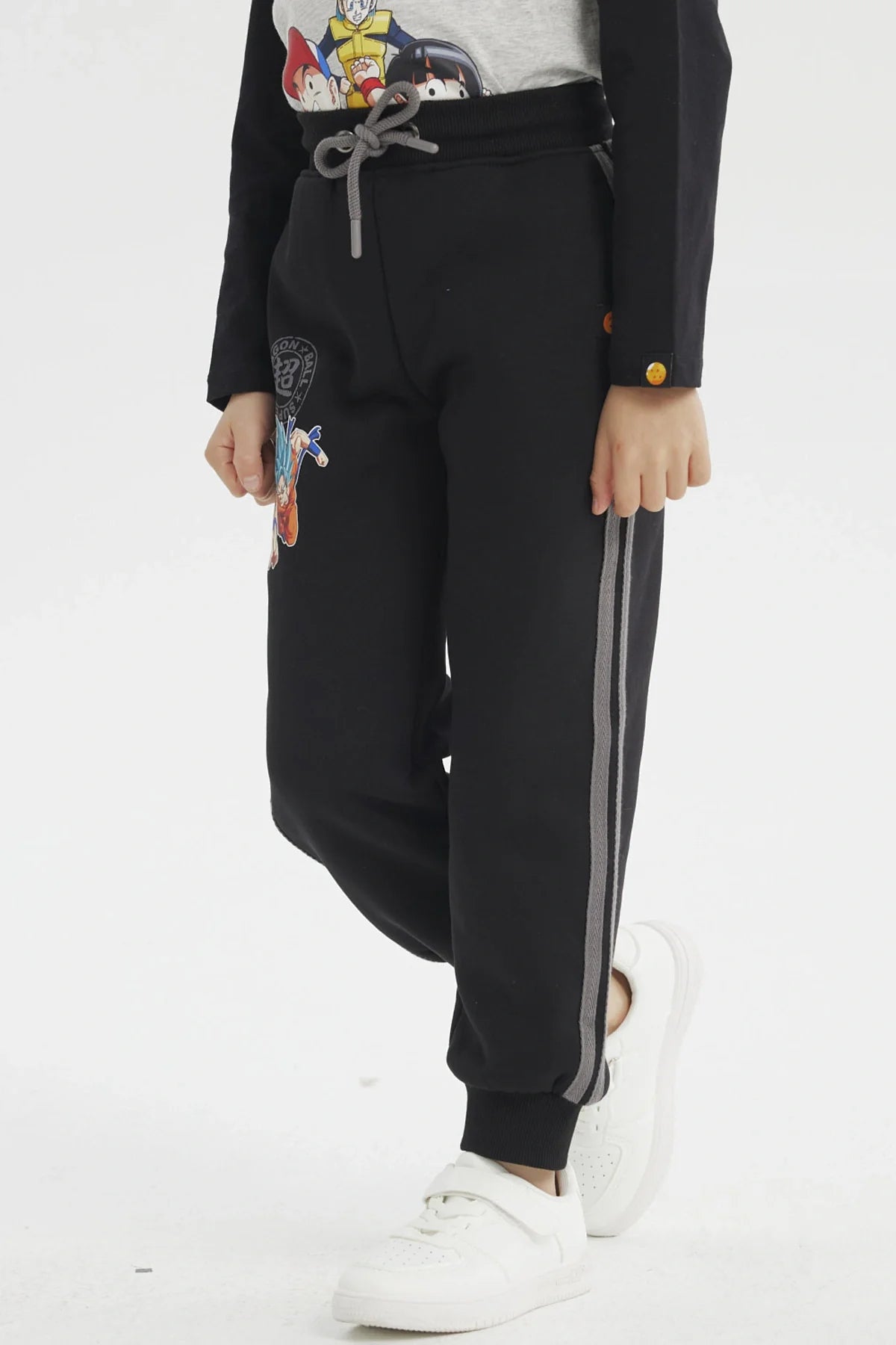 Pantalón buzo negro con estampado de Goku en acción, detalles en gris y logo de Dragon Ball, ideal para fans que buscan comodidad y estilo.