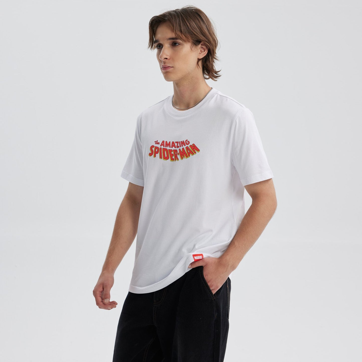 Polera blanca de algodón con el texto "the AMAZING SPIDER-MAN" en un vibrante estilo retro, ideal para los fans del icónico héroe de Marvel.