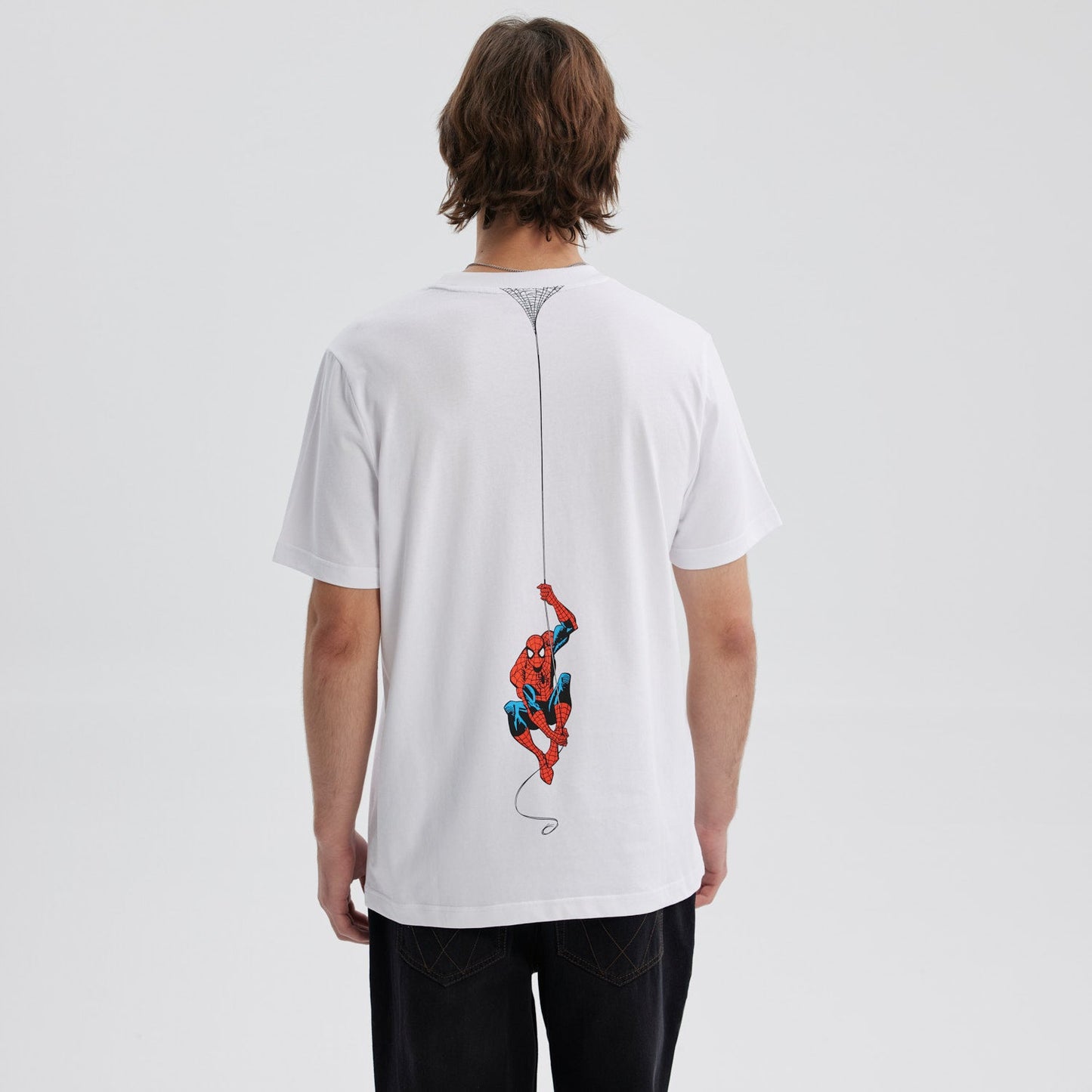 Polera blanca de algodón con el texto "the AMAZING SPIDER-MAN" en un vibrante estilo retro, ideal para los fans del icónico héroe de Marvel.