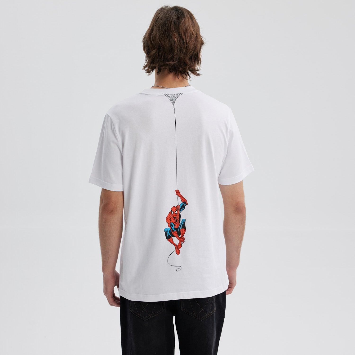 Polera blanca de algodón con el texto "the AMAZING SPIDER-MAN" en un vibrante estilo retro, ideal para los fans del icónico héroe de Marvel.
