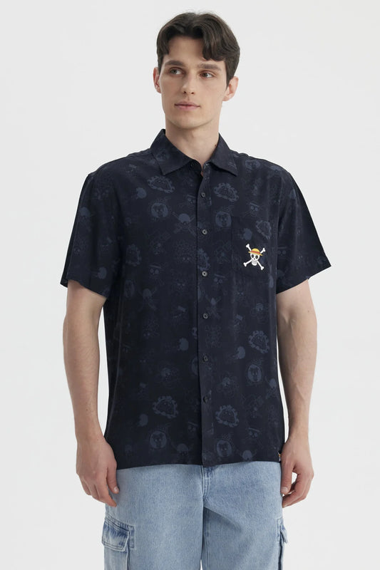 Camisa de manga corta negra con estampado sutil de personajes de One Piece, incluye el icónico logo de la tripulación de Luffy en el pecho.