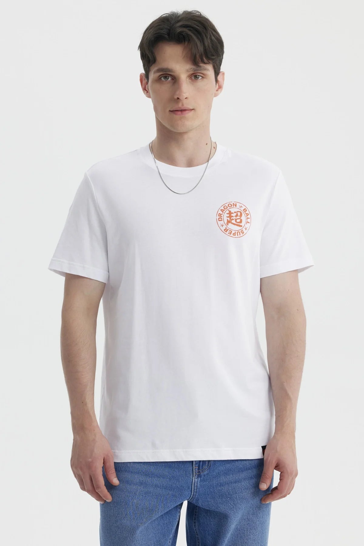 Polera blanca de Dragon Ball con estampado circular en naranja que dice 'DRAGON BALL SUPER' y símbolo kanji, ideal para fans del anime.