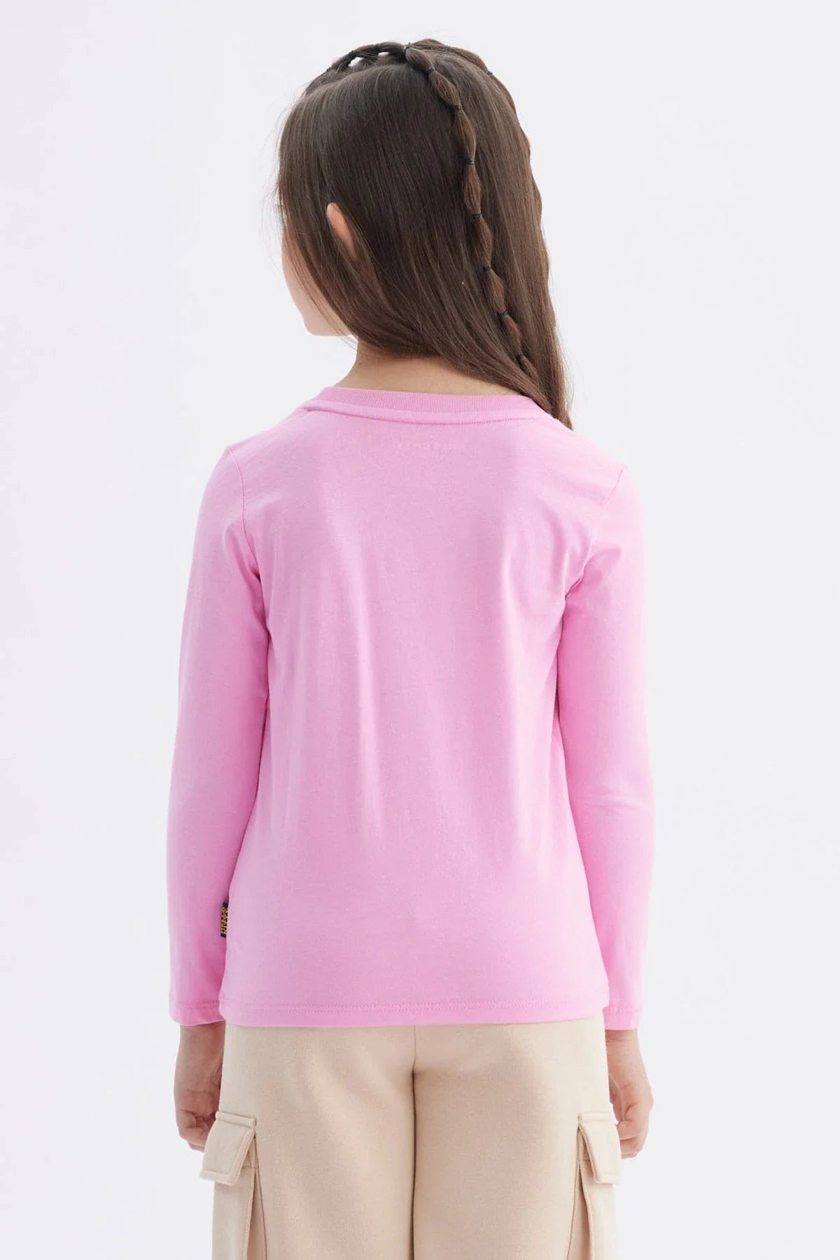 Polera de manga larga en color rosado con un diseño central de Hello Kitty vistiendo un conjunto negro, acompañado del texto 'HELLO KITTY' en letras brillantes.