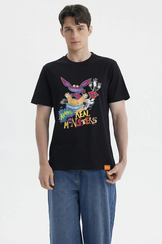 Polera negra de algodón con estampado colorido de personajes de Aaahh!!! Real Monsters, mostrando a Ickis, Oblina y Krumm en acción, ideal para fans nostálgicos.