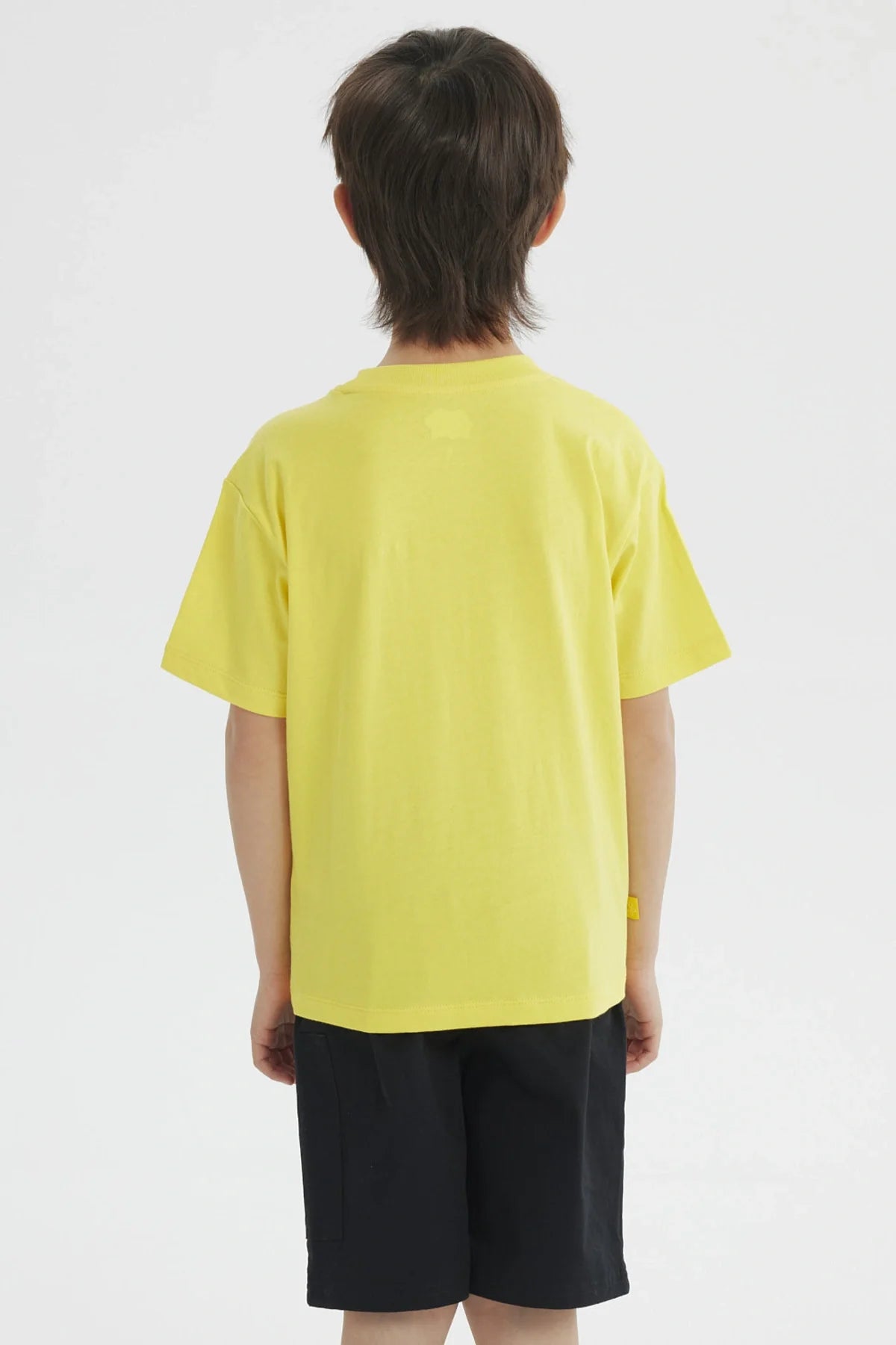 Polera amarilla de algodón con un divertido diseño de Bob Esponja en el bolsillo, que dice 'Welcome to Bikini Bottom', ideal para fans de la serie.