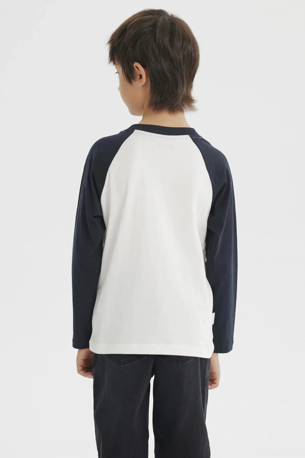 Polera de manga larga azul marino con cuerpo blanco, presenta a Bluey en acción sobre un fondo de colores suaves, ideal para fans de la serie australiana.