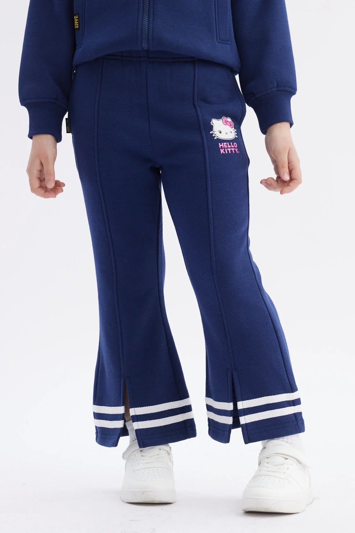 Pantalón buzo azul marino con detalles deportivos, presenta un estampado de Hello Kitty en la pierna, ideal para los fans de Sanrio.