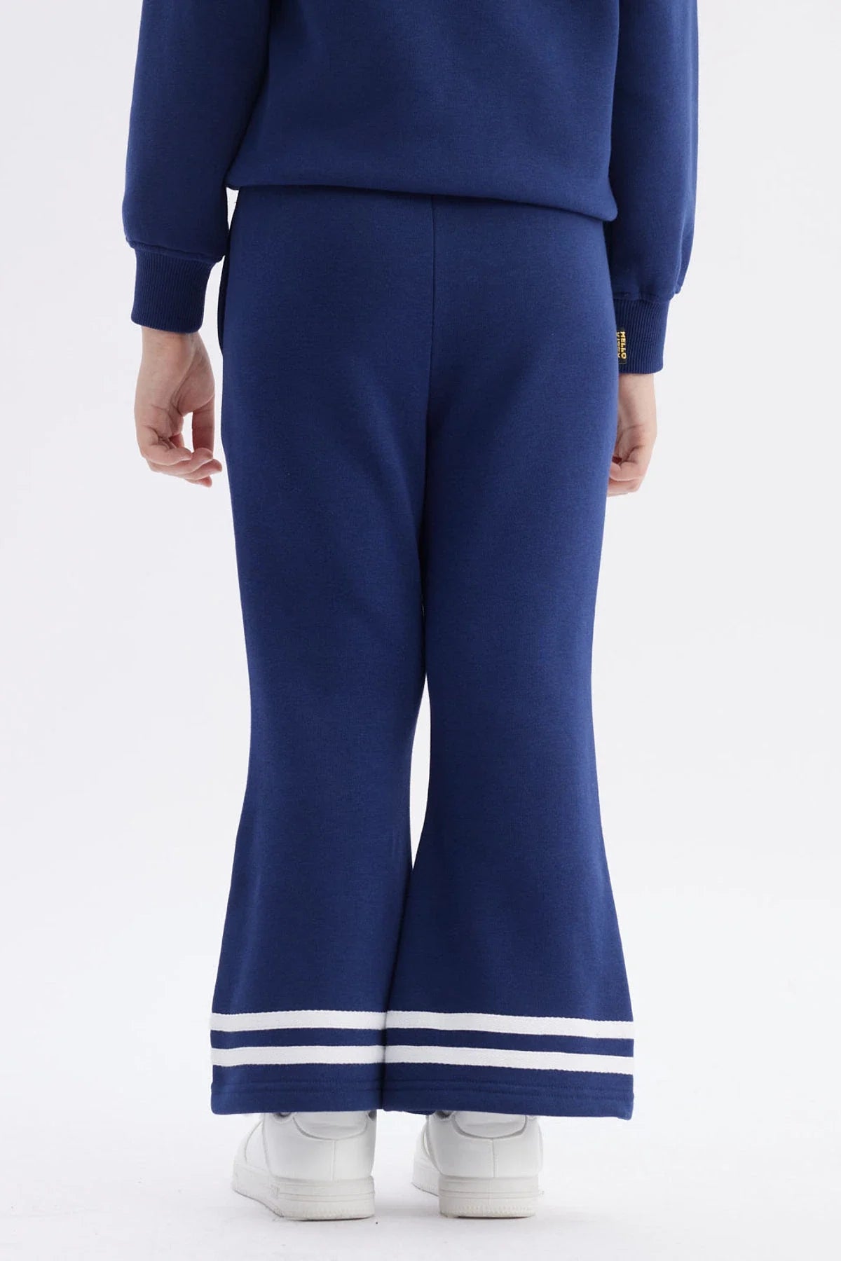 Pantalón buzo azul marino con detalles deportivos, presenta un estampado de Hello Kitty en la pierna, ideal para los fans de Sanrio.