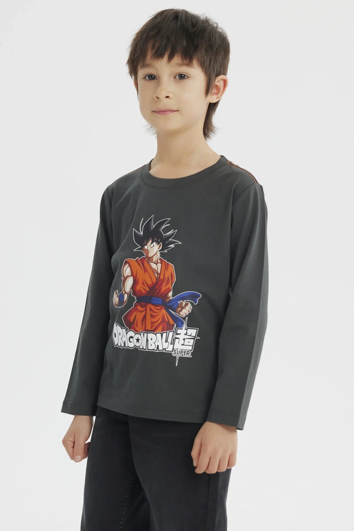 Polera gris melange con ilustración de Goku en su traje naranja de Dragon Ball Super, destacando su energía y determinación en un diseño vibrante.