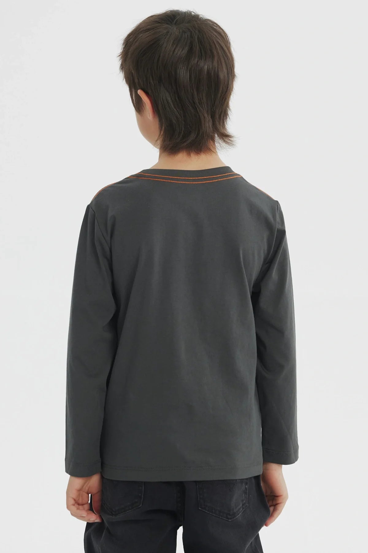 Polera gris melange con ilustración de Goku en su traje naranja de Dragon Ball Super, destacando su energía y determinación en un diseño vibrante.
