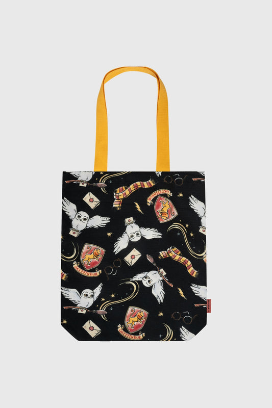 Bolsa negra con estampado de búhos, varitas y escudos de Gryffindor, detalles en amarillo, ideal para fans de Harry Potter.
