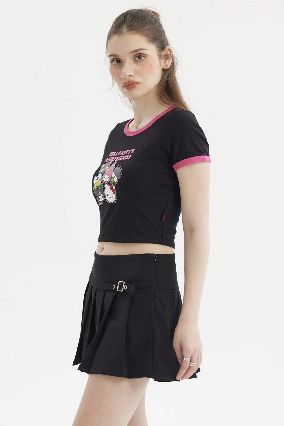 Polera negra de Hello Kitty con ribete rosa, presenta un diseño vibrante de Hello Kitty y sus amigos en estilo cartoon, ideal para fans de Sanrio.