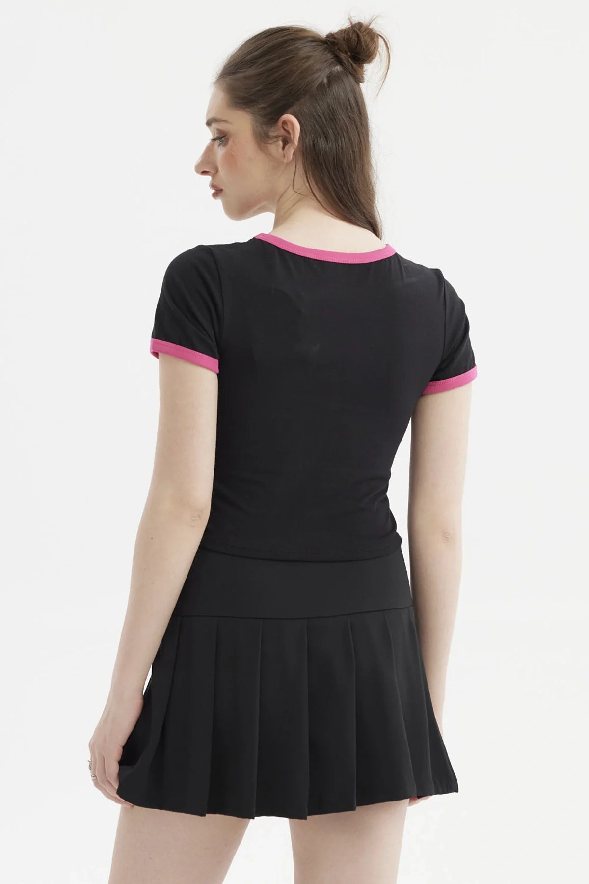 Polera negra de Hello Kitty con ribete rosa, presenta un diseño vibrante de Hello Kitty y sus amigos en estilo cartoon, ideal para fans de Sanrio.