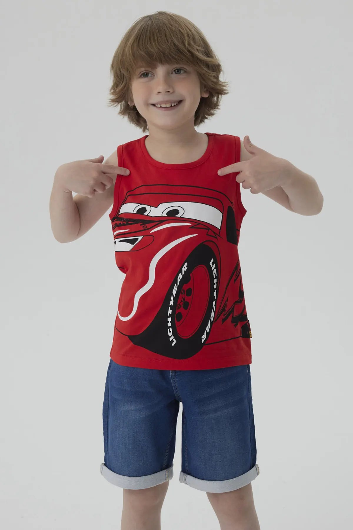 Polera roja de algodón con estampado de Rayo McQueen, el famoso auto de Cars, mostrando su icónica sonrisa y llantas, perfecta para fans de Pixar.
