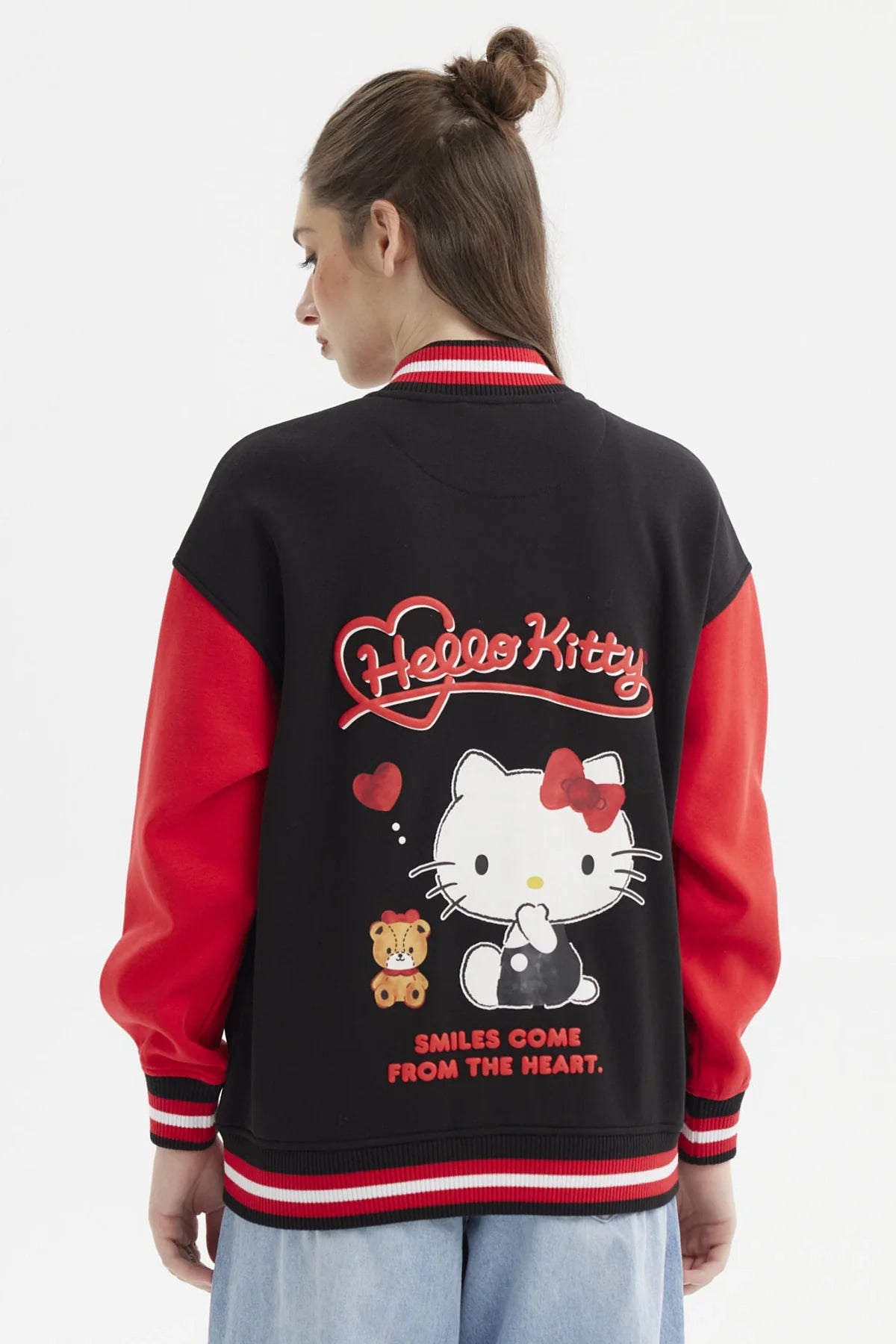 Polerón negro con mangas rojas, presenta un diseño de Hello Kitty en el pecho y el logo en rojo, ideal para fans de la icónica gatita.