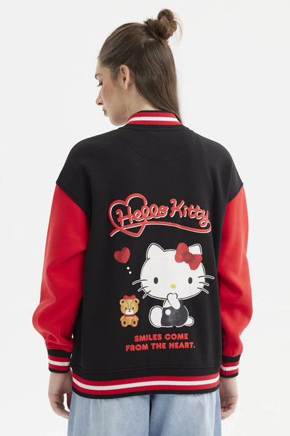 Polerón negro con mangas rojas, presenta un diseño de Hello Kitty en el pecho y el logo en rojo, ideal para fans de la icónica gatita.