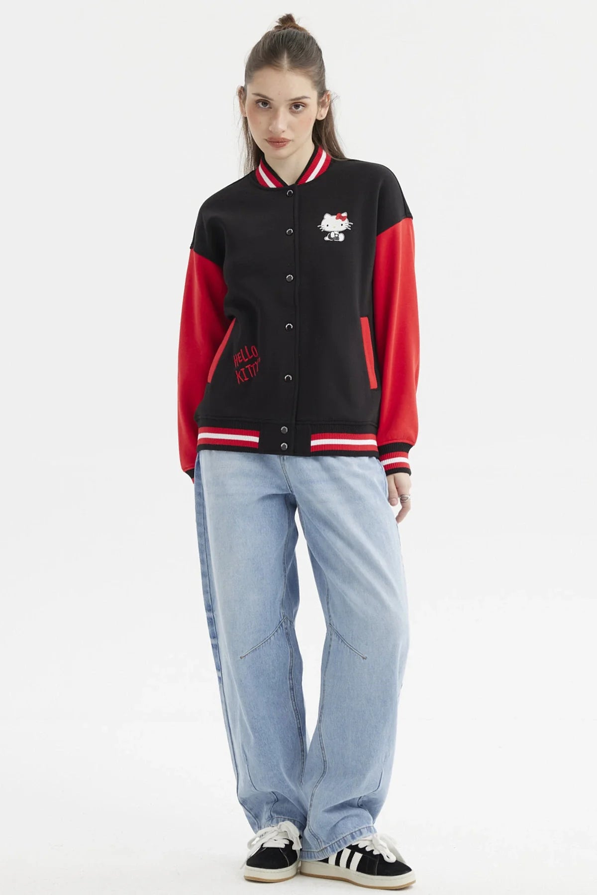 Polerón negro con mangas rojas, presenta un diseño de Hello Kitty en el pecho y el logo en rojo, ideal para fans de la icónica gatita.