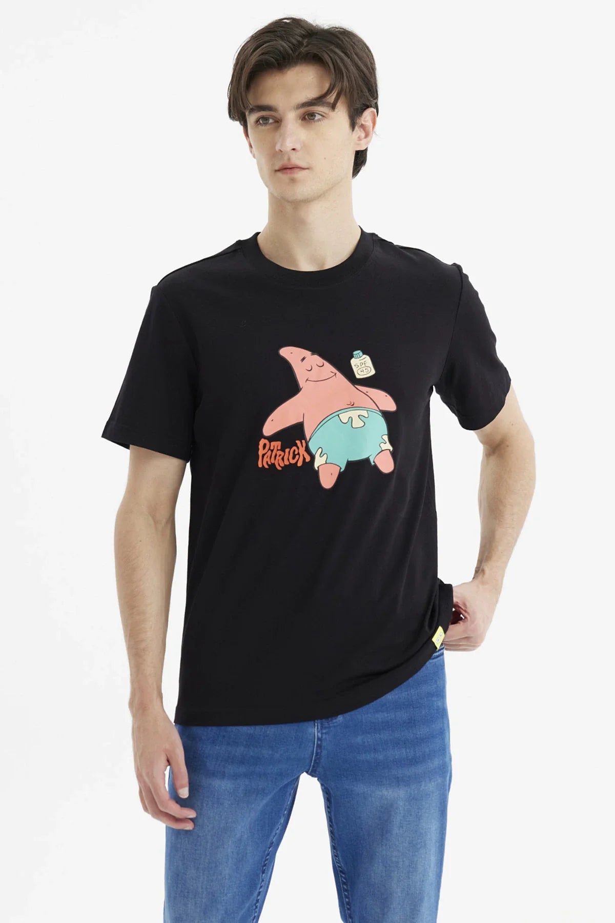 Polera negra de algodón con ilustración de Patricio Estrella, sonriente y relajado, usando pantalones cortos celestes, destacando su icónico nombre en rojo.