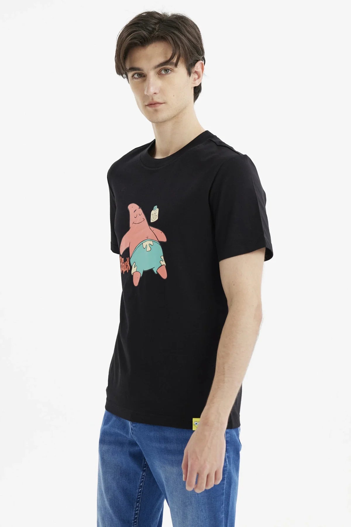 Polera negra de algodón con ilustración de Patricio Estrella, sonriente y relajado, usando pantalones cortos celestes, destacando su icónico nombre en rojo.