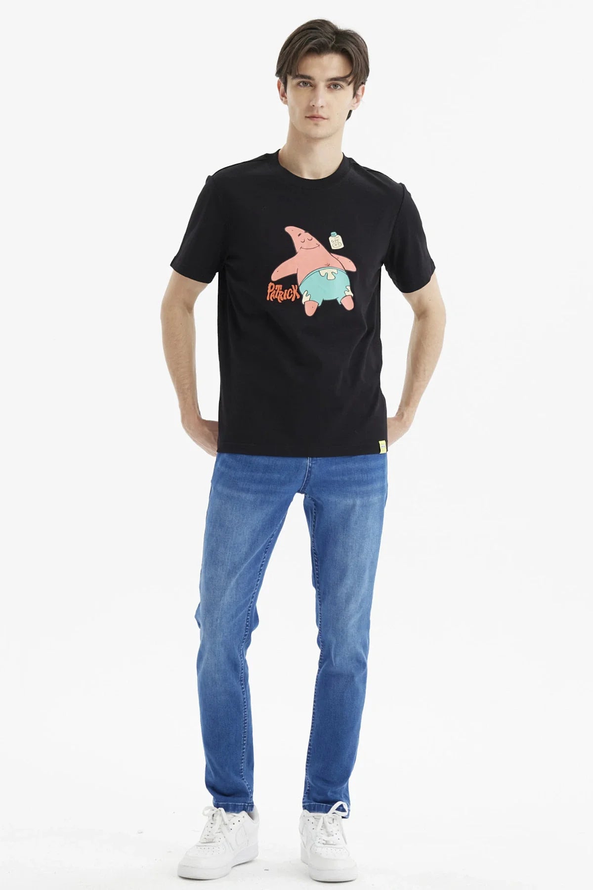 Polera negra de algodón con ilustración de Patricio Estrella, sonriente y relajado, usando pantalones cortos celestes, destacando su icónico nombre en rojo.