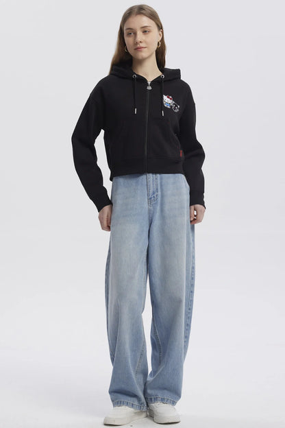 Polerón negro con capucha y cierre, presenta un diseño de Hello Kitty y su amigo negro, ideal para fans de Sanrio que buscan estilo y comodidad.