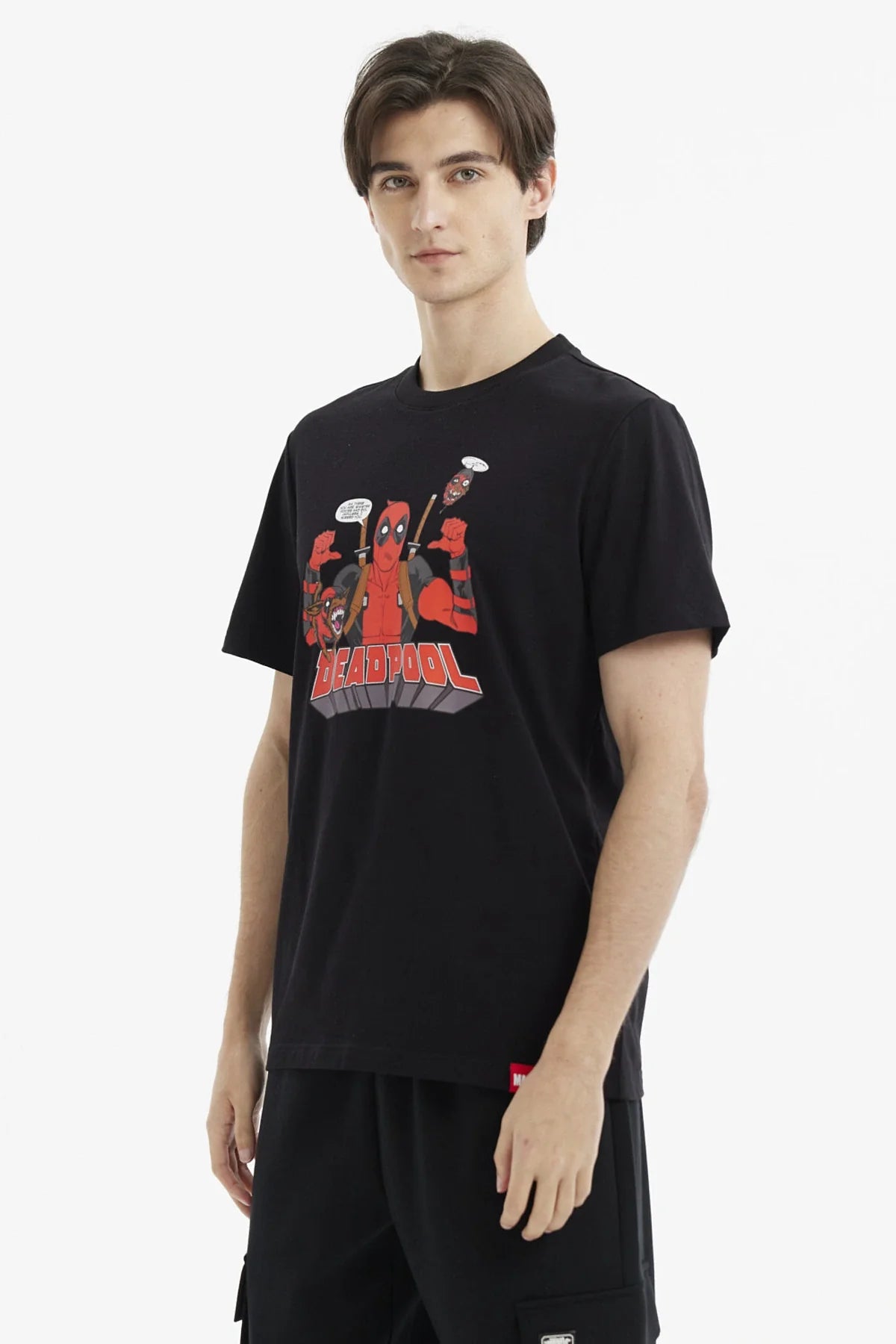 Polera negra de algodón con ilustración de Deadpool en el centro, mostrando su icónico traje rojo y negro, acompañado de personajes cómicos, en estilo caricaturesco.
