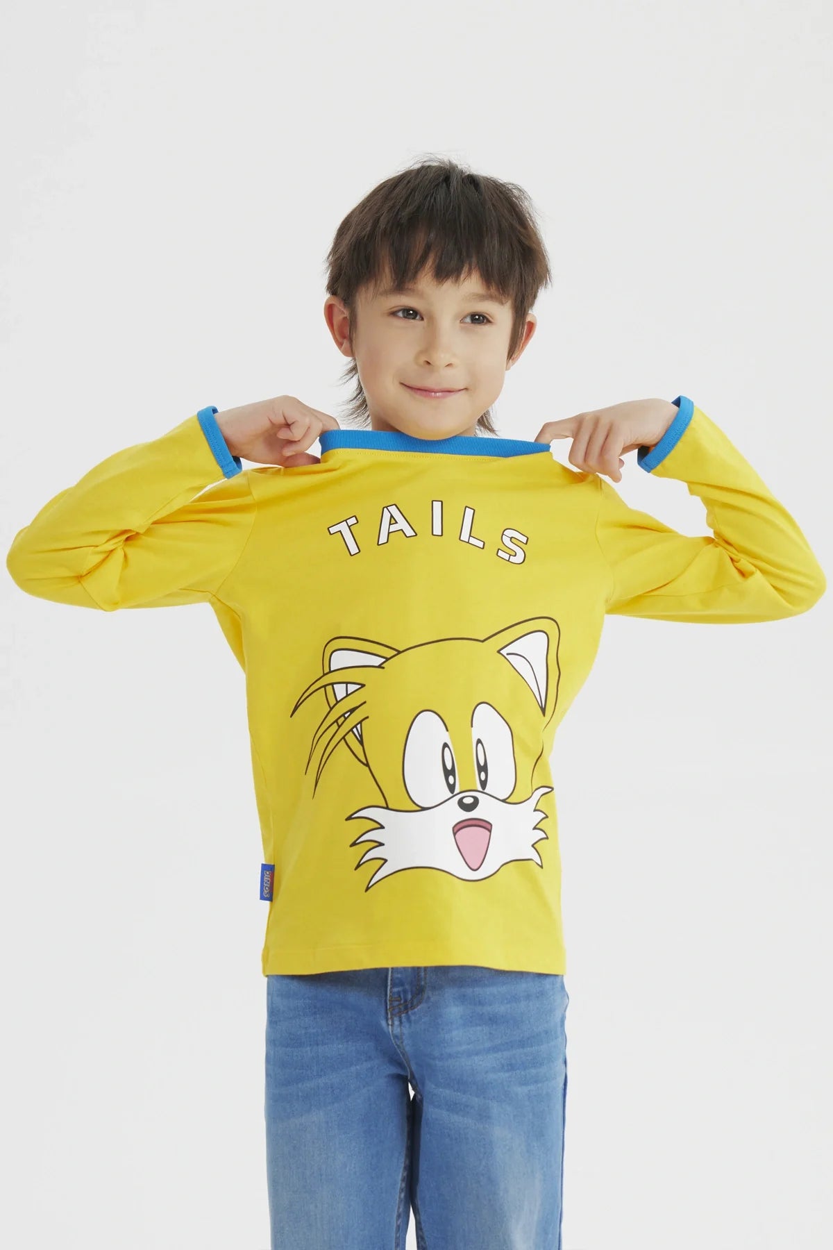 Polera amarilla de Sonic con el rostro de Tails en el centro, detalles en azul en el cuello, ideal para fans de videojuegos y la saga Sonic.