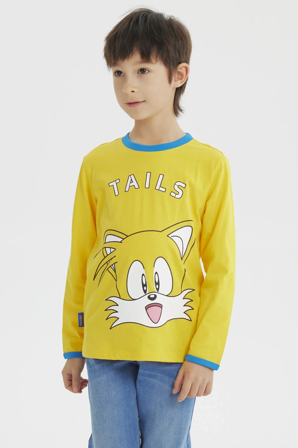 Polera amarilla de Sonic con el rostro de Tails en el centro, detalles en azul en el cuello, ideal para fans de videojuegos y la saga Sonic.