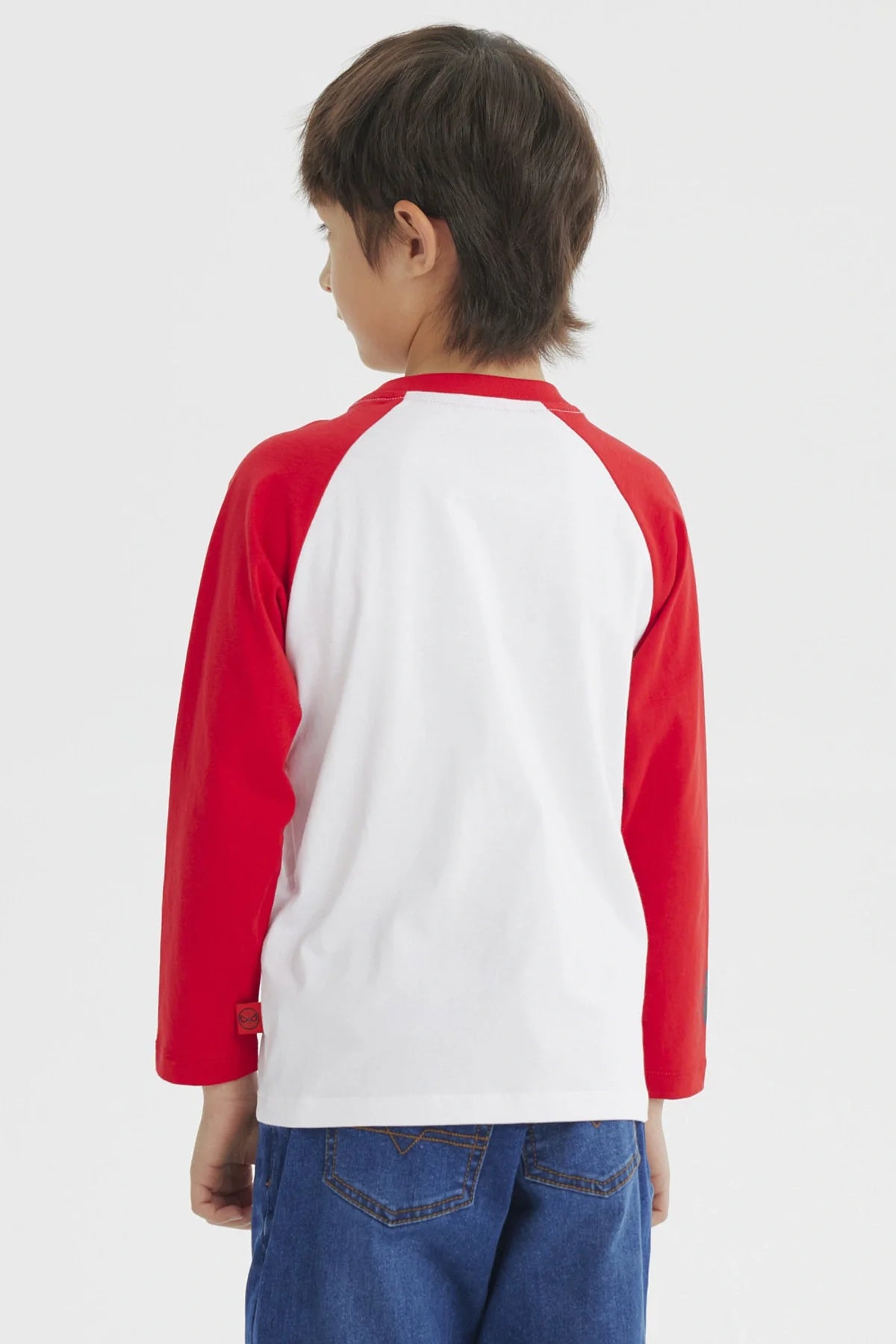Polera Spiderman blanca con mangas rojas, presenta una ilustración vibrante de Spiderman en acción sobre una telaraña, ideal para fans de Marvel.