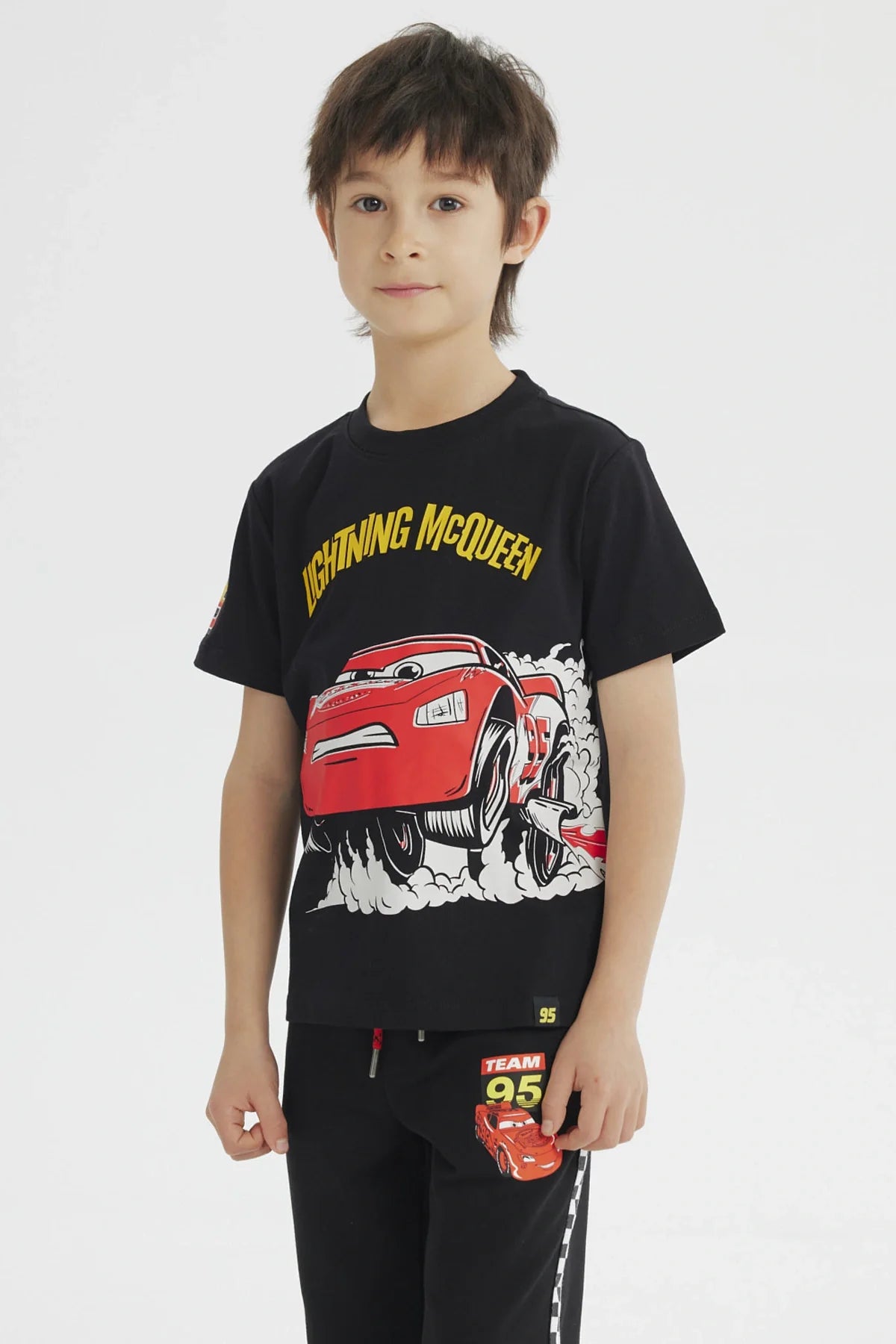 Polera negra de algodón con ilustración de Rayo McQueen en acción, destacando su velocidad y carisma, ideal para fans de Cars.