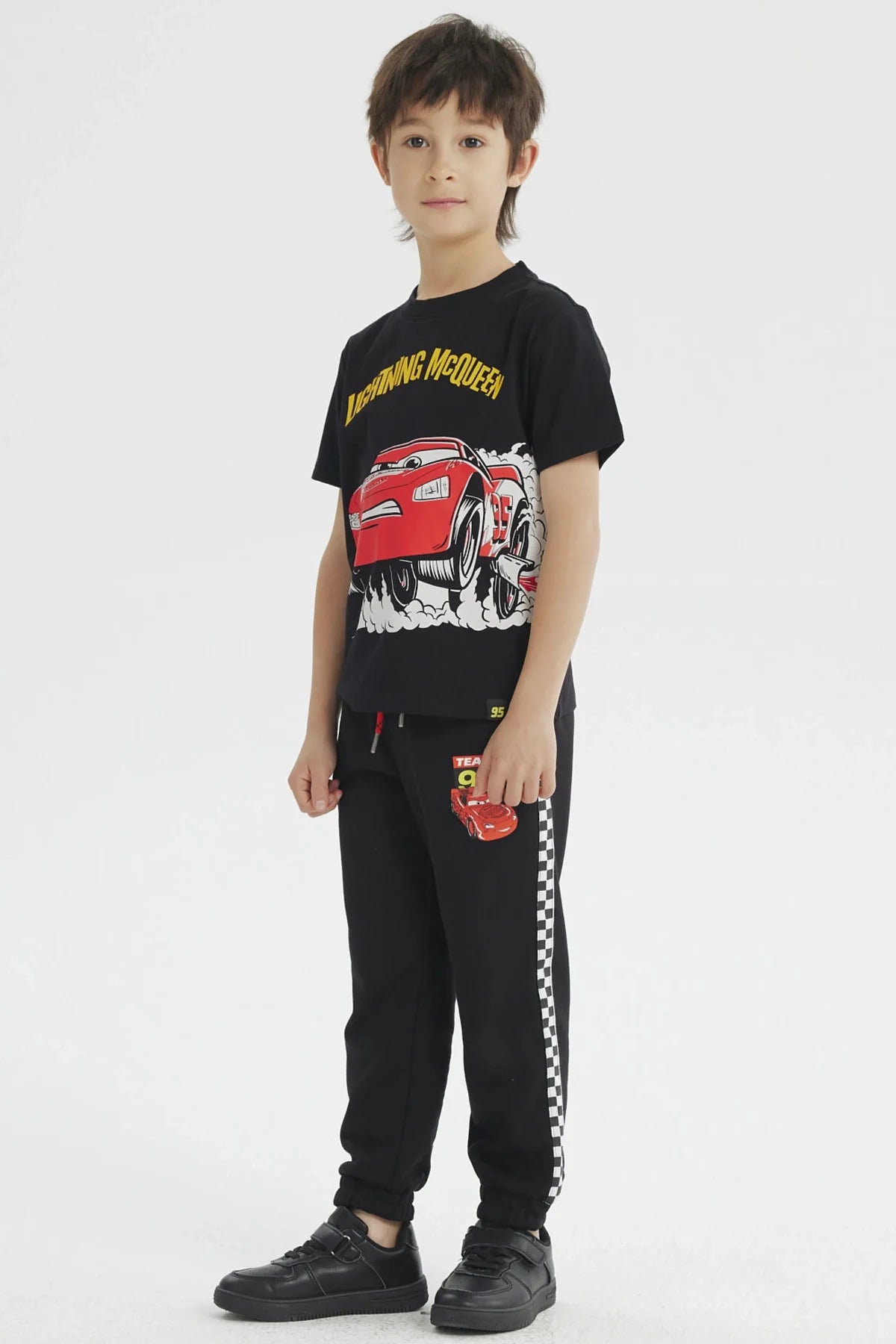 Polera negra de algodón con ilustración de Rayo McQueen en acción, destacando su velocidad y carisma, ideal para fans de Cars.