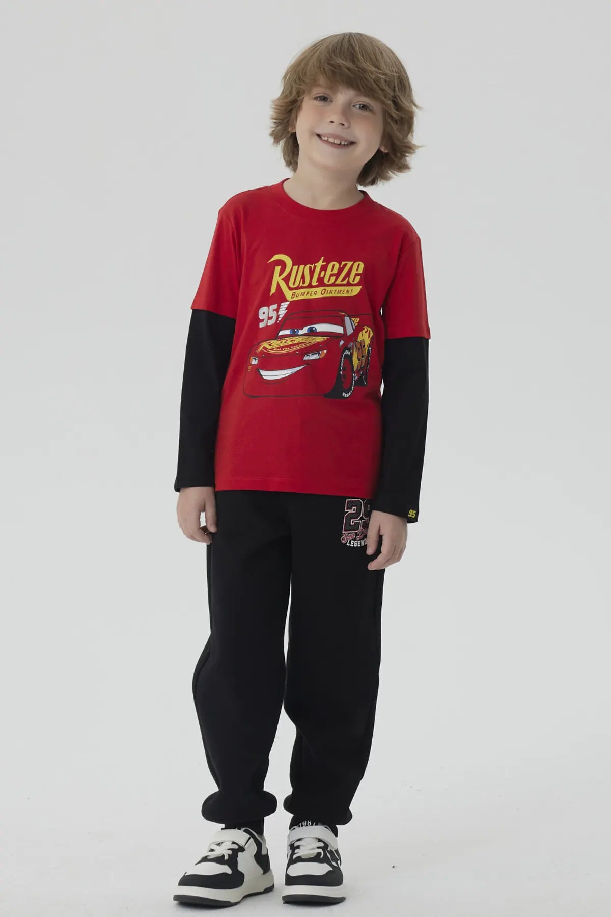 Polera roja de niño con estampado de Rayo McQueen de Cars, presenta el logo 'Rust-eze' y el número 95, ideal para los pequeños fanáticos de Pixar.