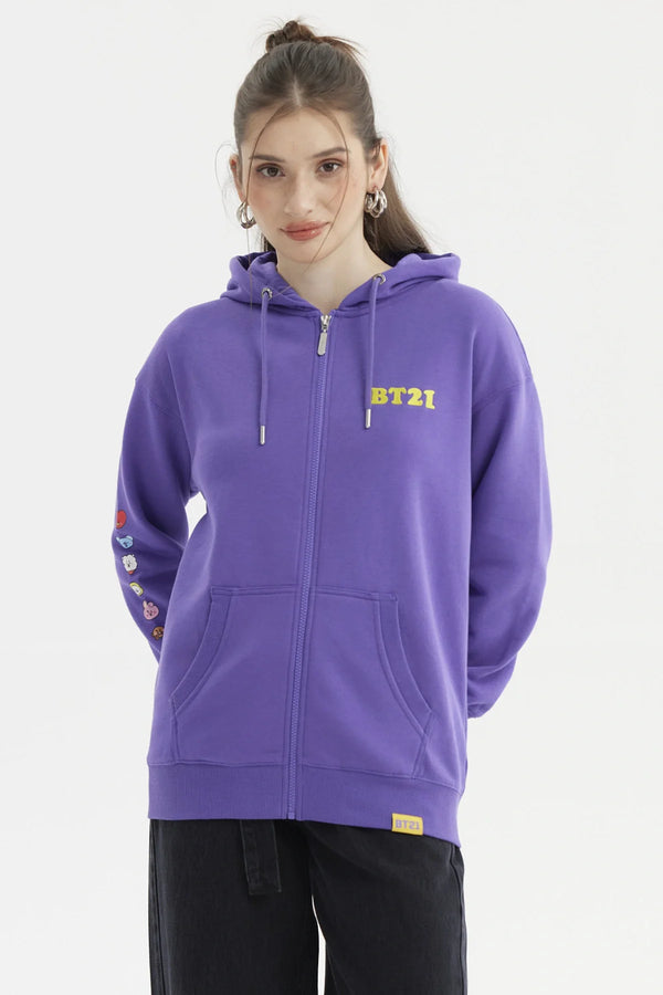 Polerón violeta con cierre, logo BT21 en amarillo, detalles de personajes en la manga, ideal para fans de BTS y su universo creativo.