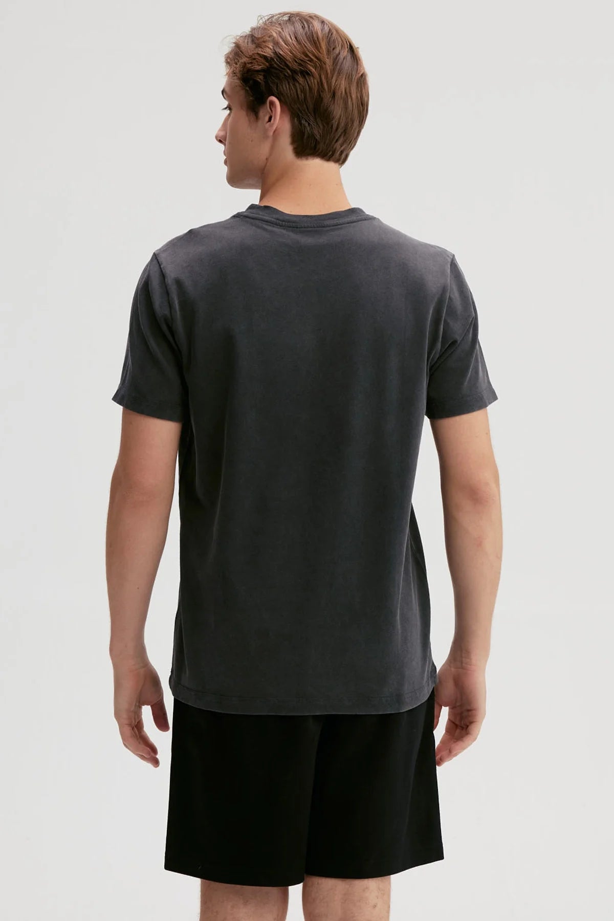 Polera negra de algodón 100% con diseño minimalista de logo en el pecho, ideal para los fanáticos de la moda urbana y el estilo casual.