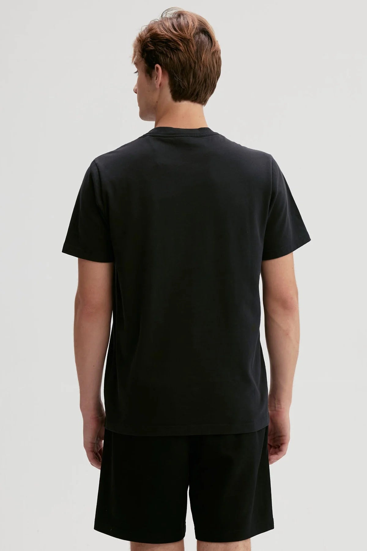 Polera negra de algodón con un diseño minimalista que presenta un logo sutil en el pecho, ideal para los fans de la moda urbana y el estilo casual.