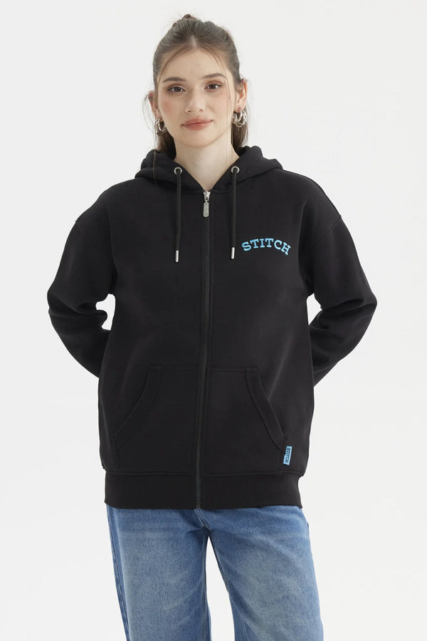 Polerón negro con capucha y cierre, presenta el texto 'STITCH' en azul sobre el pecho, ideal para fans de Lilo & Stitch.