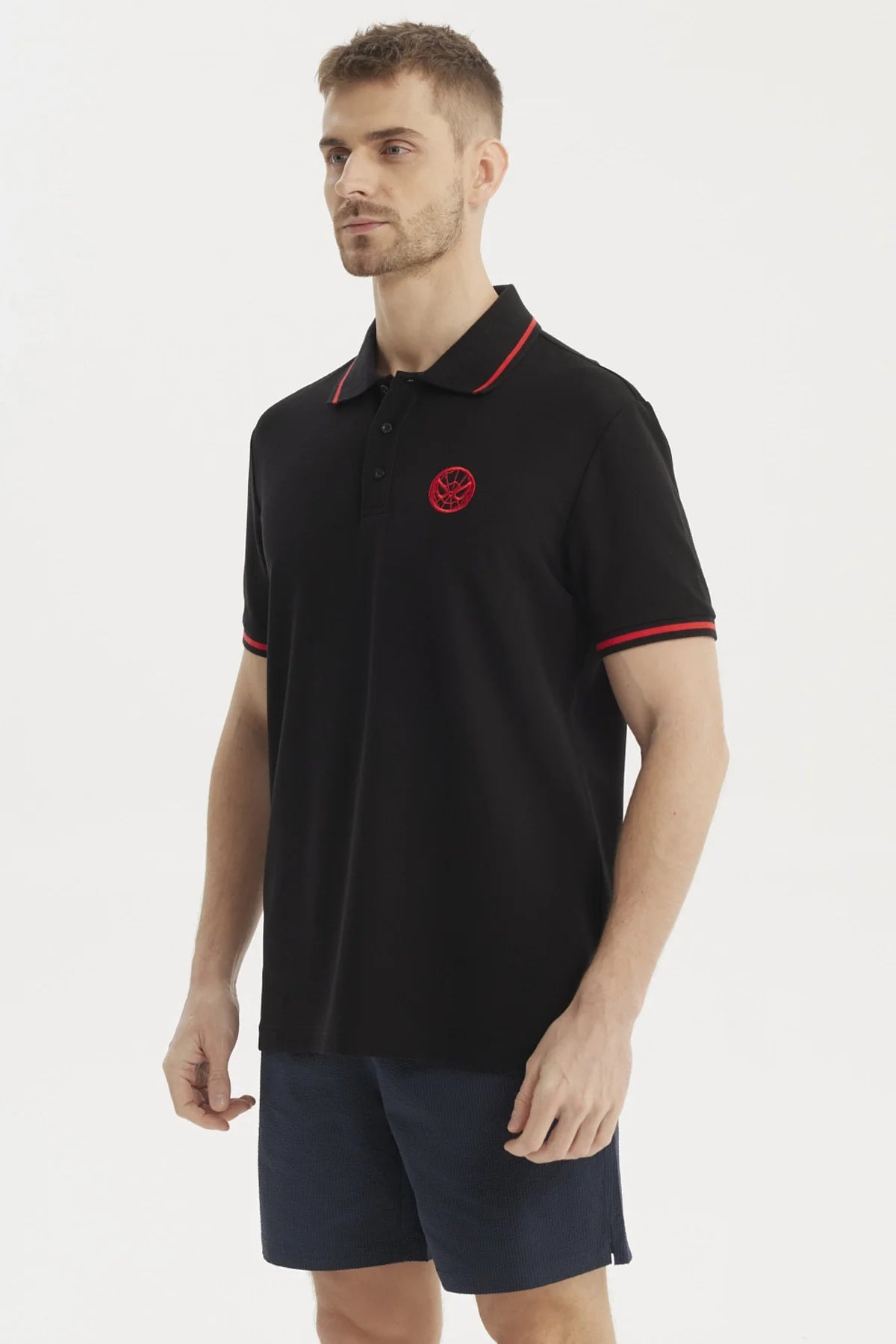 Polera piqué negra con detalles en rojo y logo de Spider-Man bordado en el pecho, ideal para fans del universo Marvel que buscan estilo y comodidad.