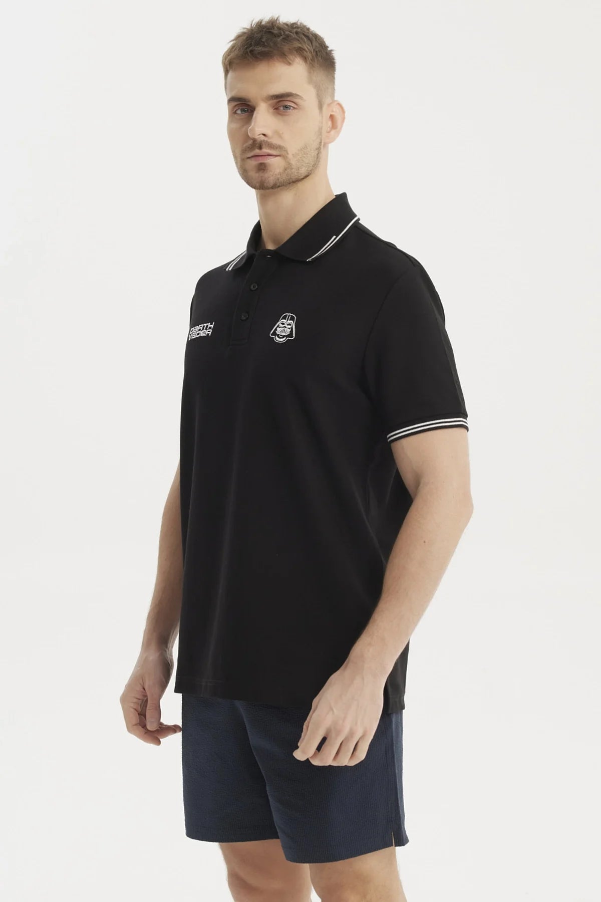 Polera Piqué negra con detalles en blanco, presenta el icónico casco de Darth Vader y la frase 'DEATH VADER', ideal para fans de Star Wars.