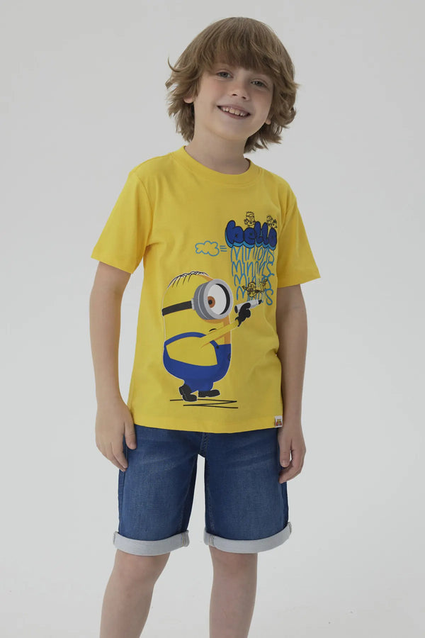 Polera amarilla de algodón con un Minion caricaturesco sosteniendo un lápiz, acompañado de un texto divertido en azul, ideal para fans de la saga Despicable Me.