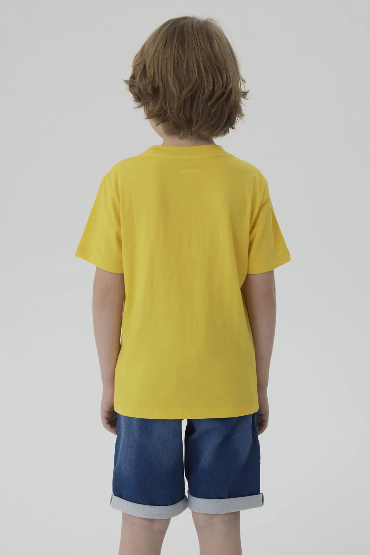 Polera amarilla de algodón con un Minion caricaturesco sosteniendo un lápiz, acompañado de un texto divertido en azul, ideal para fans de la saga Despicable Me.